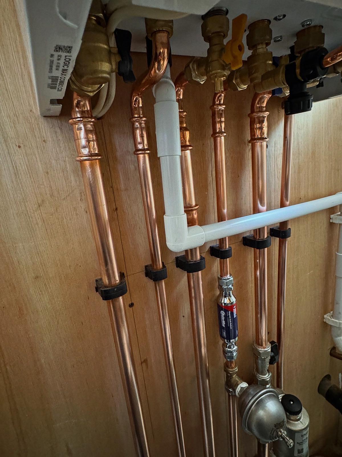 Close-up of copper pipework and filtration on a boiler install.